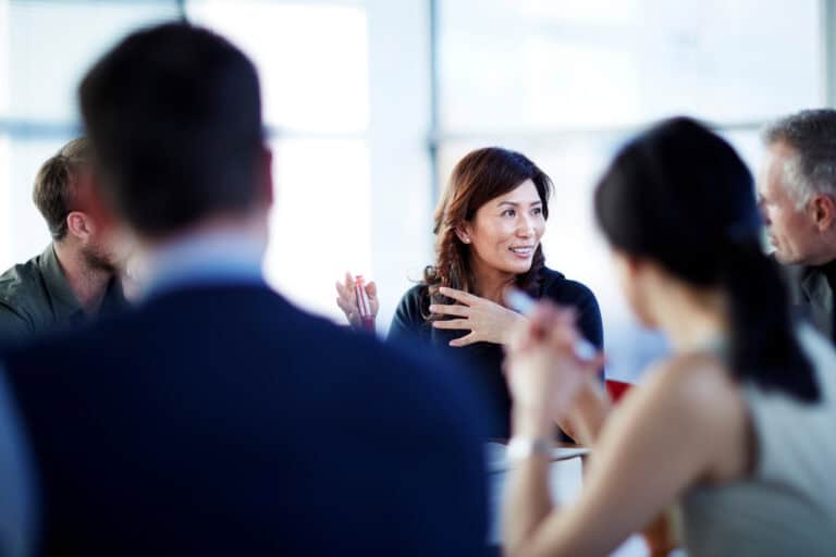 Business professionals engaged in a recruitment discussion at a corporate meeting.